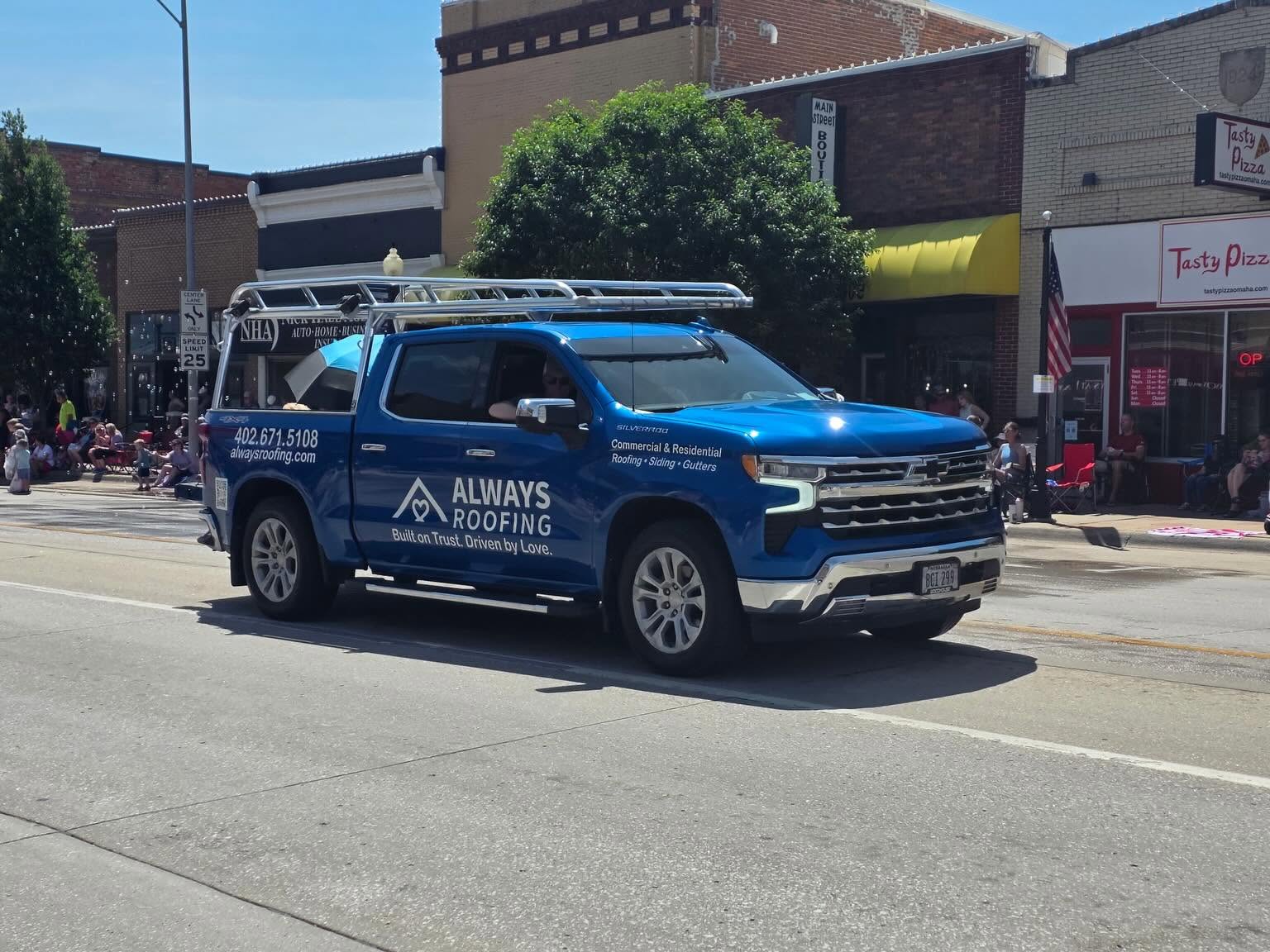 Always Roofing's blue truck at a community parade